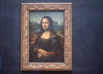 A Man Dressed As Old Lady Throws Cake At  The Mona Lisa Painting